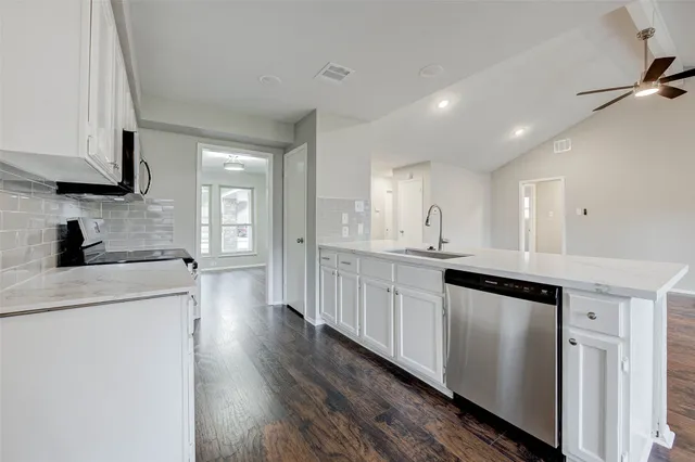 a kitchen with stainless steel appliances granite countertop a sink a stove and a refrigerator