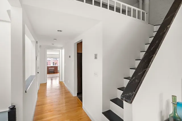 a view of a hallway with wooden floor and entryway