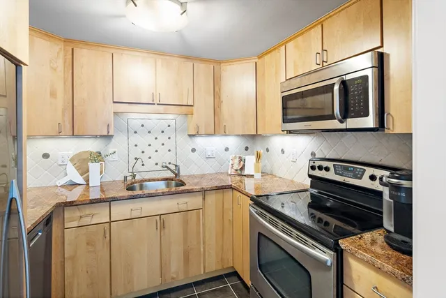 a kitchen with appliances a sink and cabinets