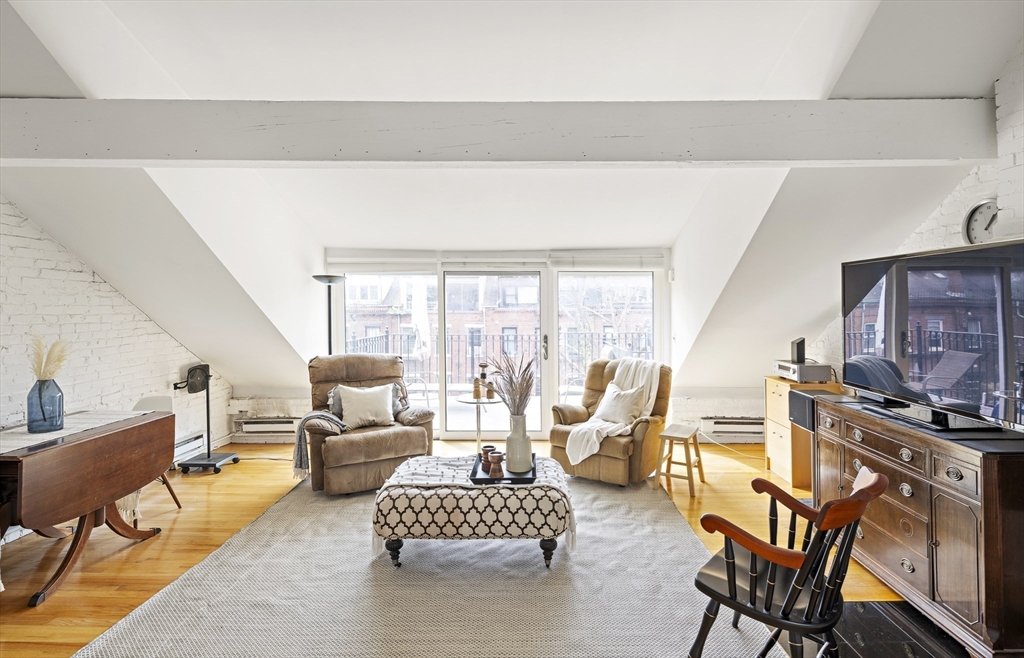 116 West Concord Street, Unit PH Boston, MA 02118 - Photo 7 of 16 a living room with furniture wooden floor and a fireplace