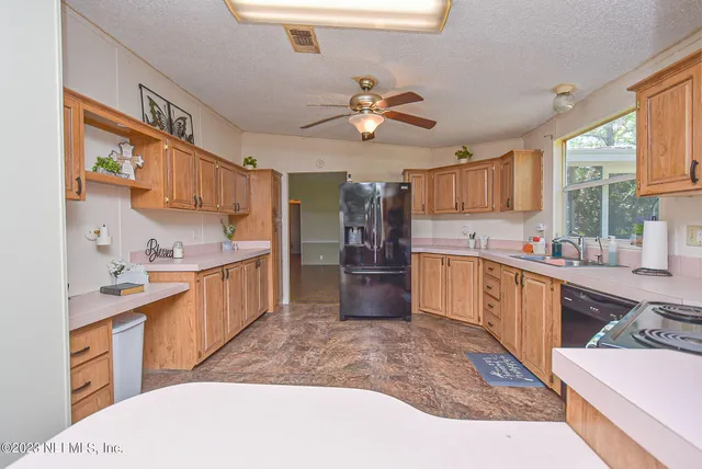 a kitchen with stainless steel appliances kitchen island granite countertop a sink stove and refrigerator