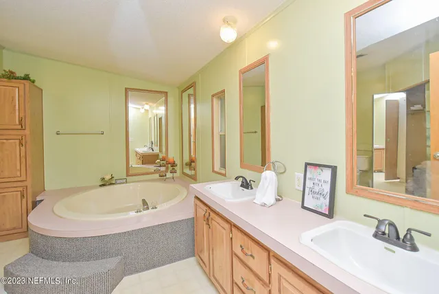 a bathroom with a tub sink and mirror
