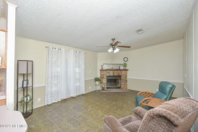 a living room with furniture a fireplace and a chandelier