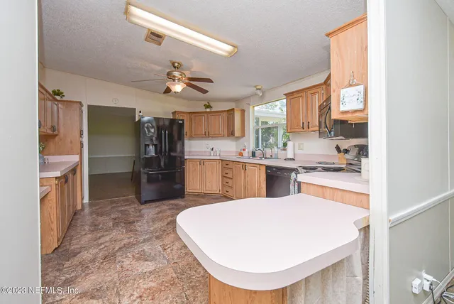 a open kitchen with kitchen island a large counter top space appliances and cabinets