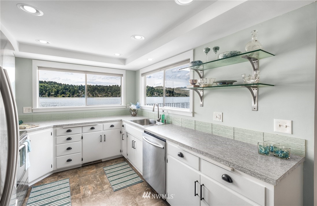6417 Ripley Ln S East Renton, WA 98056 - Photo 13 of 39 a kitchen with granite countertop white cabinets white appliances and a large window