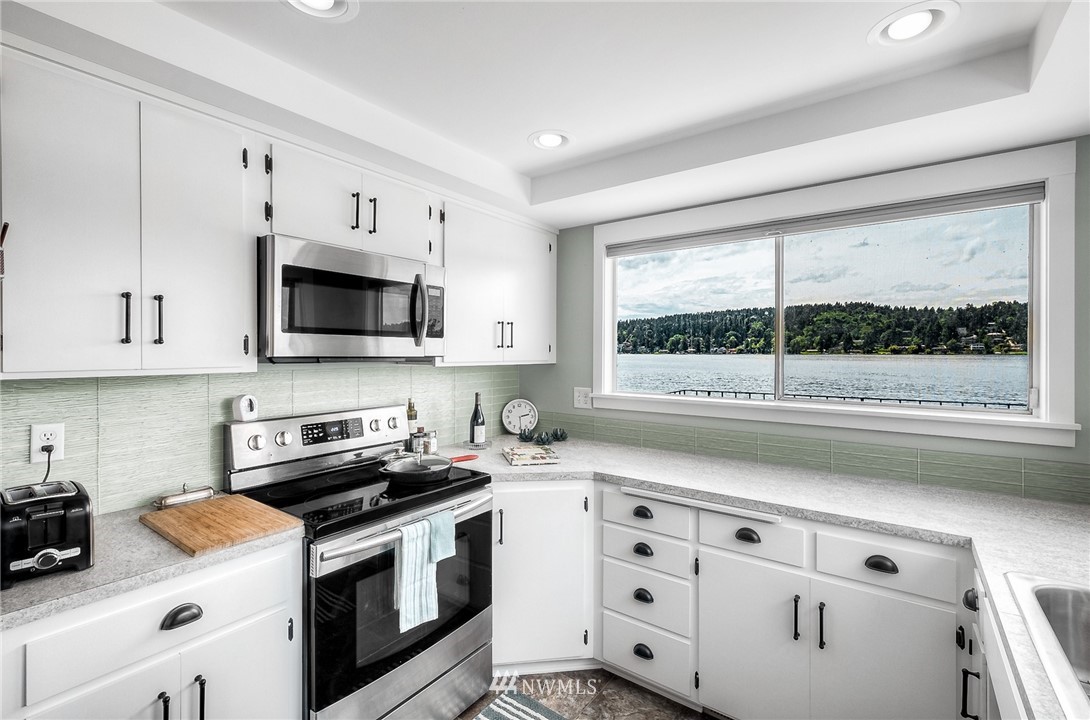 6417 Ripley Ln S East Renton, WA 98056 - Photo 14 of 39 a kitchen with granite countertop white cabinets and window