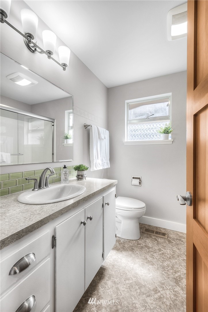 6417 Ripley Ln S East Renton, WA 98056 - Photo 10 of 39 a bathroom with a granite countertop toilet sink and mirror