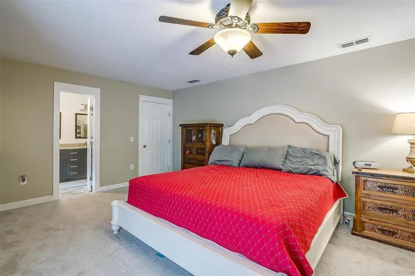 a bedroom with a large bed and a chandelier