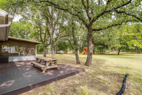 a view of a house with backyard and tree