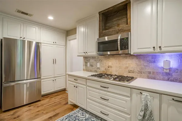 a kitchen with granite countertop cabinets and steel stainless steel appliances