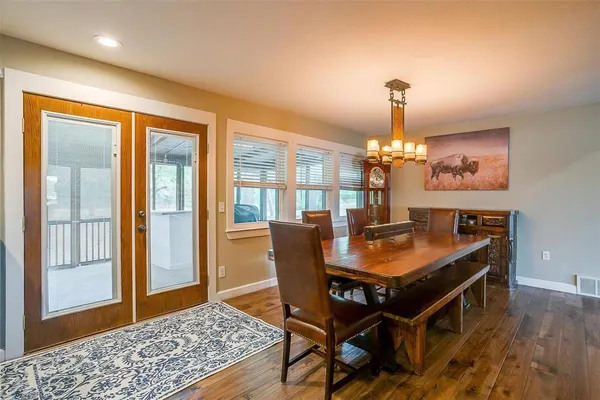 a dining room with furniture a chandelier and wooden floor