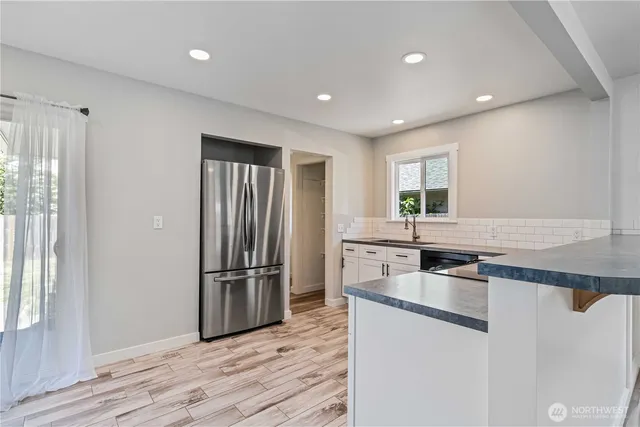 a kitchen with granite countertop a refrigerator stove and sink