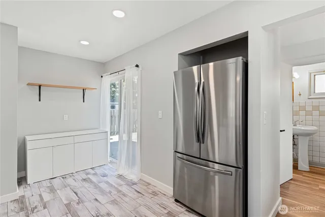 a view of a kitchen with a refrigerator and wooden floor