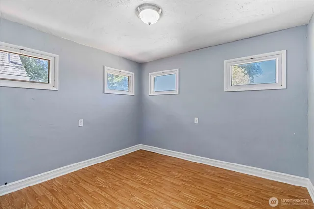 a view of empty room with wooden floor