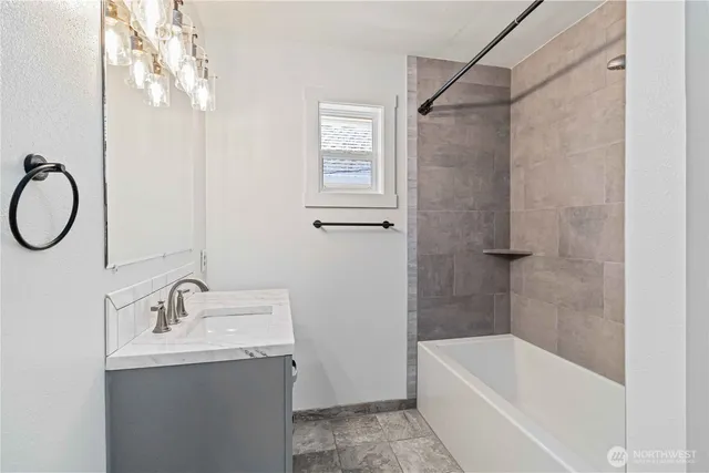 a bathroom with a sink a mirror a bathtub and shower