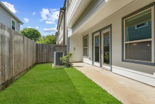 a view of a backyard with table and chairs and wooden fence