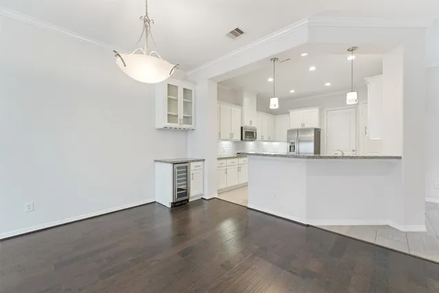 an open kitchen with kitchen island white cabinets and stainless steel appliances