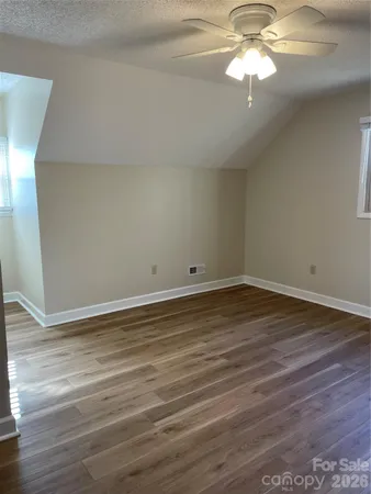 a large bedroom with a bed and wooden floor