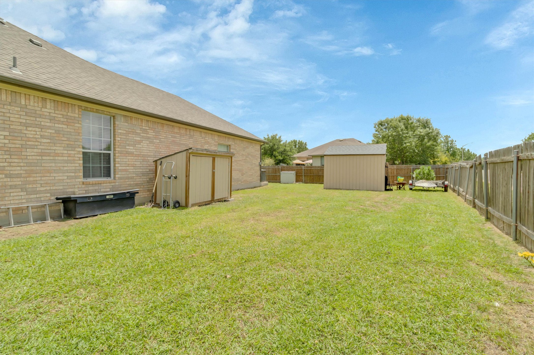 460 Waterleaf Boulevard Kyle, TX 78640 - Photo 26 of 30 A well-maintained yard provides ample outdoor space, complete with multiple storage sheds for convenience.