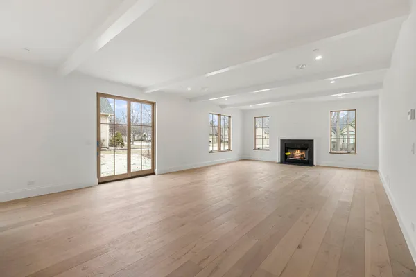 a view of an empty room with window and a fireplace