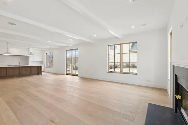 a view of an empty room with a window and fireplace