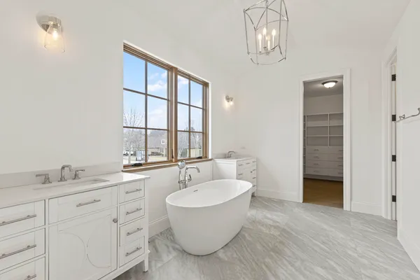 a bathroom with a double vanity sink a mirror and a bathtub