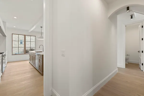 a view of a hallway with bathroom and wooden floor