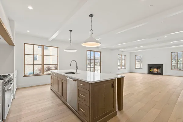 a large kitchen with stainless steel appliances granite countertop a stove and a wooden floors