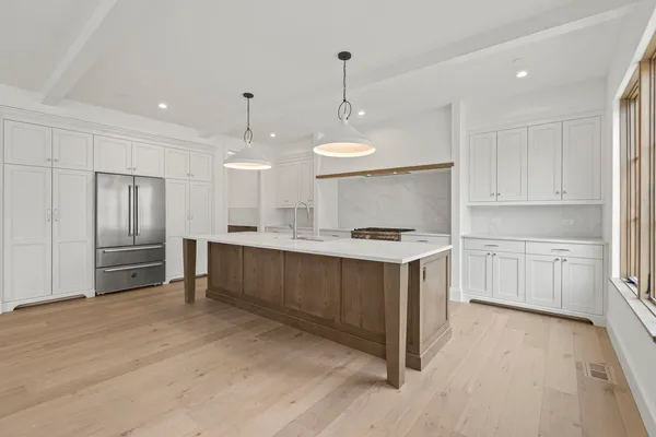 a kitchen with kitchen island white cabinets and stainless steel appliances