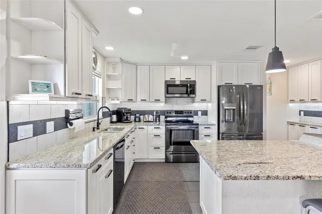 a kitchen with stainless steel appliances granite countertop a sink stove oven and refrigerator
