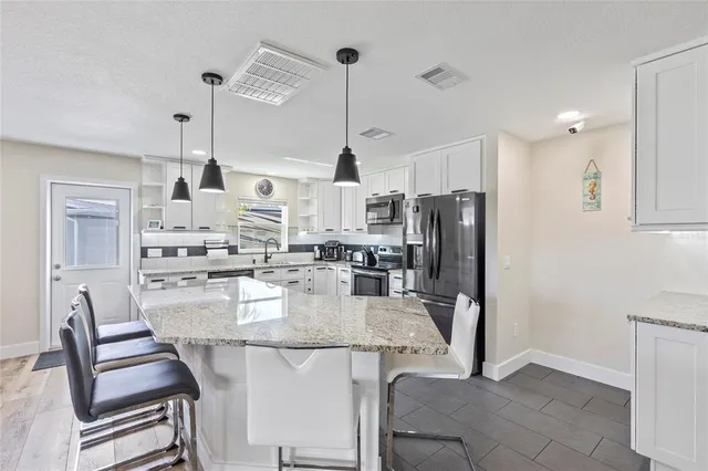 a kitchen with refrigerator and chairs