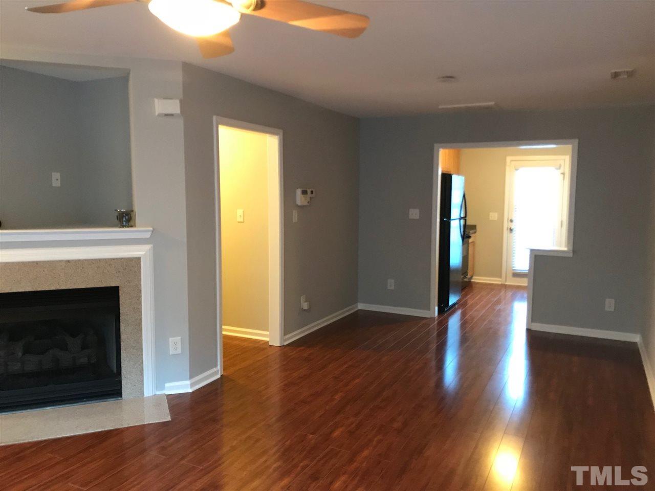 9904 Layla Avenue Raleigh, NC 27617 - Photo 5 of 19 a view of an empty room with wooden floor and a fireplace