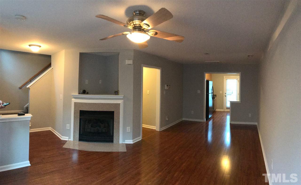 9904 Layla Avenue Raleigh, NC 27617 - Photo 6 of 19 a view of an empty room with wooden floor and a fireplace