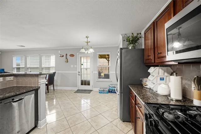 a kitchen with stainless steel appliances granite countertop a stove a sink and a microwave