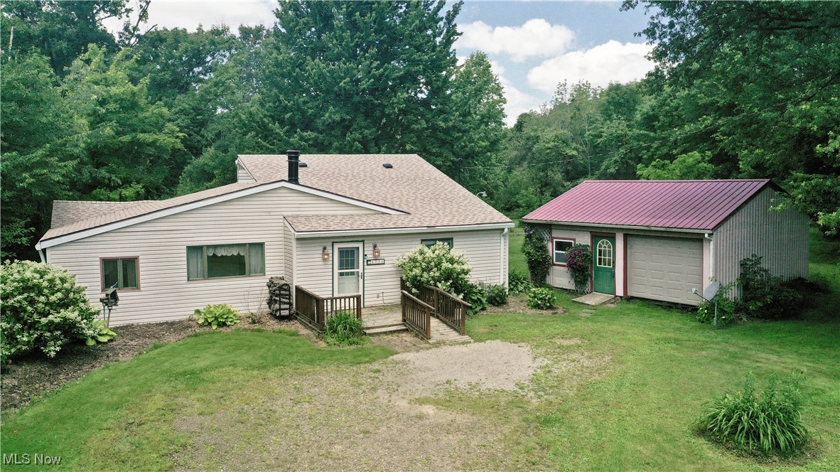 8756 Cook Road Salem, OH 44460 - Photo 6 of 50 View of front of house with a front lawn, an outbuilding, a wooden deck, and a garage