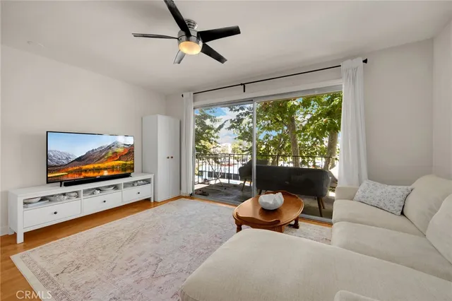 a living room with furniture flat screen tv and a large window