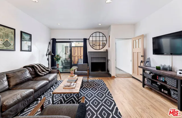 a living room with furniture a flat screen tv and a fireplace