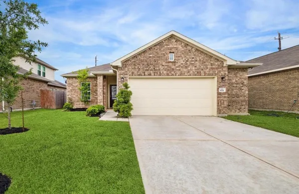 a view of a house with a small yard and a garage