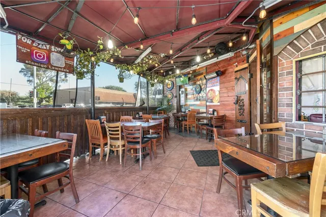 a outdoor space with lots of tables a large window and a couch