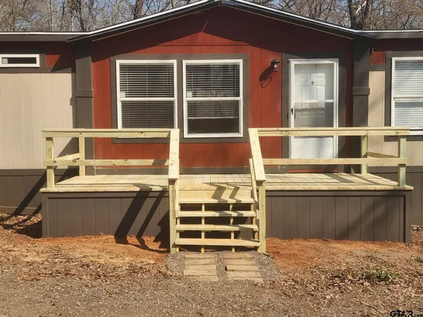 a view of a house with a wooden fence