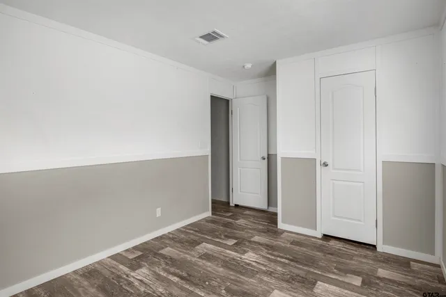 an empty room with wooden floor and closet