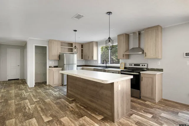 a kitchen with stainless steel appliances granite countertop a sink a stove a refrigerator and island