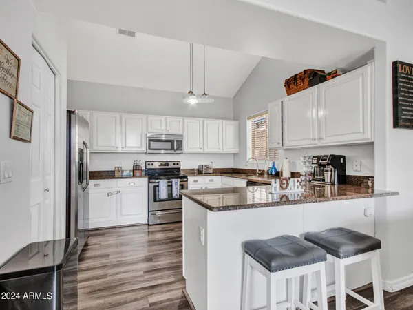 a kitchen with kitchen island granite countertop a sink and cabinets