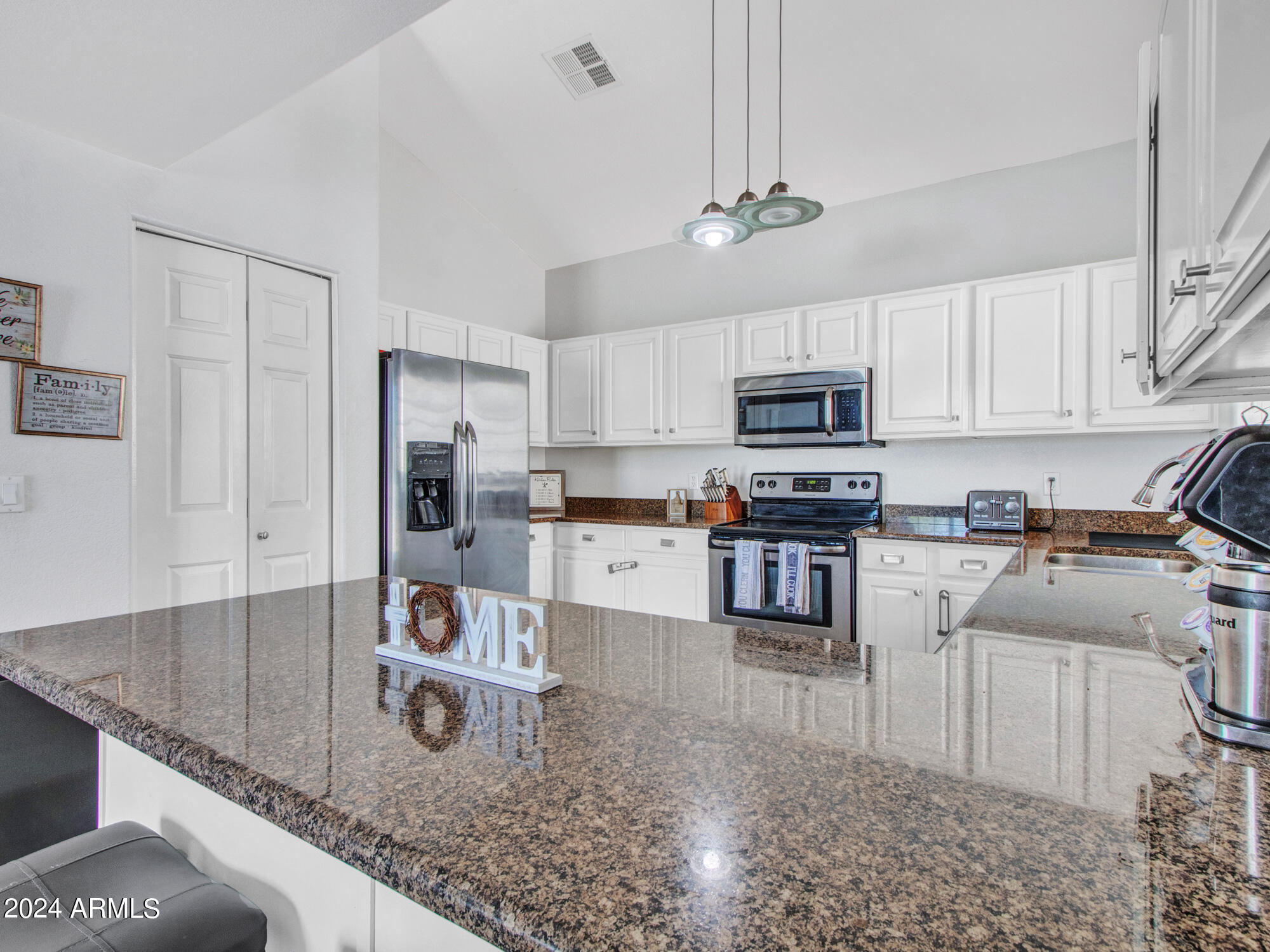 2801 North Litchfield Road, Unit 60 Goodyear, AZ 85395 - Photo 16 of 37 a kitchen with stainless steel appliances granite countertop a sink a stove top oven a counter space and cabinets
