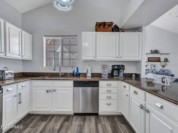 a kitchen with granite countertop white cabinets and white appliances