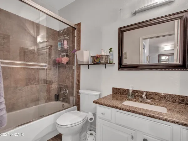 a bathroom with a granite countertop sink toilet and shower
