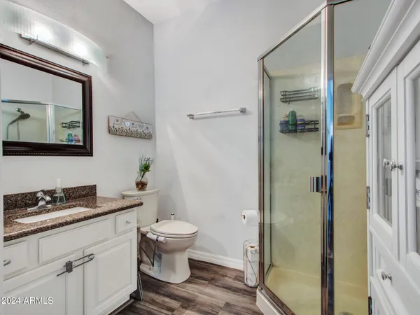 a bathroom with a granite countertop toilet and a shower