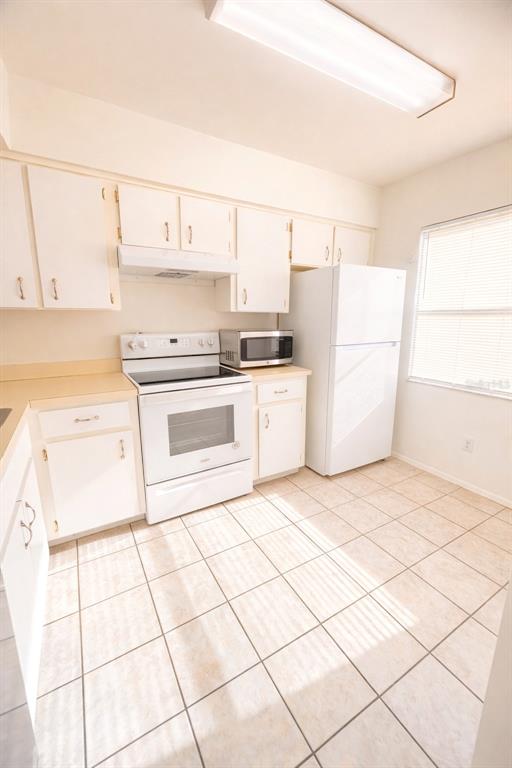 3244 Candle Ridge Drive, Unit 202 Orlando, FL 32822 - Photo 4 of 61 a kitchen with a white cabinets and white appliances