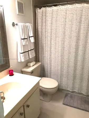 a bathroom with a sink toilet and shower curtain