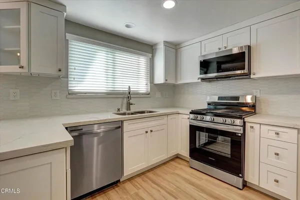 a kitchen with stainless steel appliances a stove sink and microwave